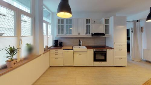 a kitchen with white cabinets and a large window at Ihr Zuhause in Jakobi's Straße in Goslar