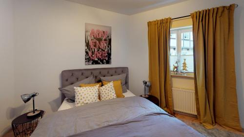 Un dormitorio con una cama con cortinas amarillas y una ventana. en Ihr Zuhause in Jakobi's Straße, en Goslar