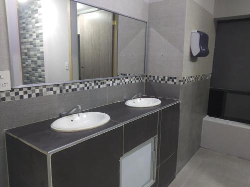 baño con 2 lavabos y espejo grande en Alameda House en Ciudad de México