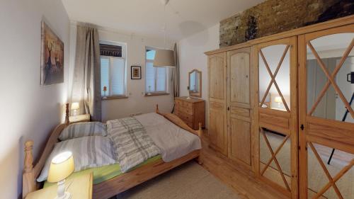 um quarto com uma cama de madeira e um armário de madeira em Ihr Zuhause am Jakobikirchhof em Goslar