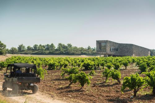 a jeep driving through a vineyard in front of a building at Village Castigno - Wine Hotel & Resort in Assignan