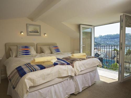 ein Schlafzimmer mit einem großen Bett und einem großen Fenster in der Unterkunft Moonrakers, Clarence Street in Dartmouth