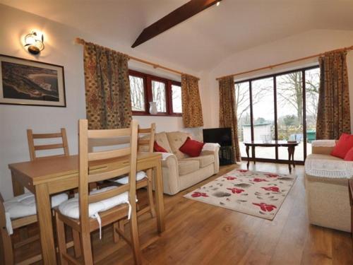 a living room with a table and a couch at Follis Cottage in Weymouth