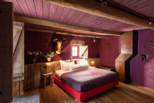 ein Schlafzimmer mit lila Wänden und ein Bett in einem Zimmer in der Unterkunft Village Castigno - Wine Hotel & Resort in Assignan