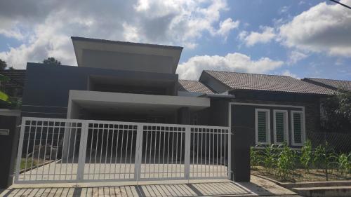 a house with a white fence in front of it at FRA Homestay in Kuantan