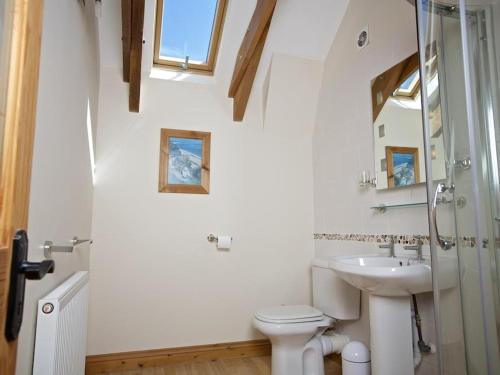 a white bathroom with a sink and a toilet at Meadow View in Ivybridge