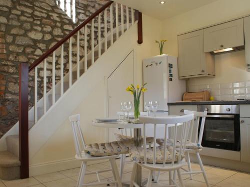 a kitchen with a table and chairs and a staircase at The Barn in Loxton