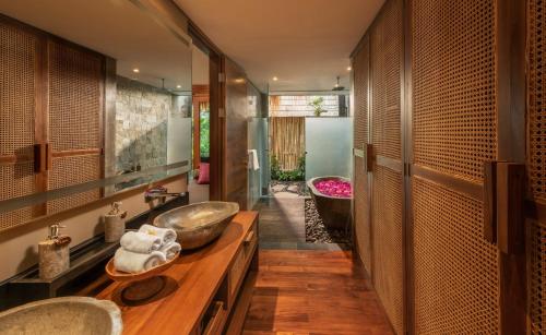 La salle de bains est pourvue de 2 lavabos et d'une baignoire. dans l'établissement Fivelements Retreat Bali, à Ubud