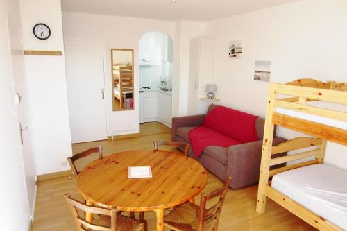 a living room with a table and a couch at Appartement Pour 4 Personnes Face A La Plage De La Graviere- Residence San Michele in Hossegor