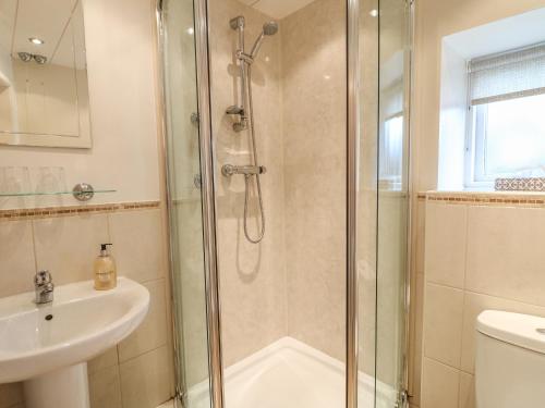 a bathroom with a shower and a sink at Barn Croft Cottage in Matlock