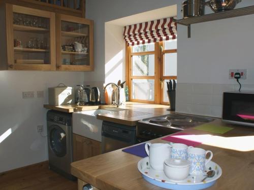 a kitchen with a table with mugs on it at Mill House Barn in Okehampton