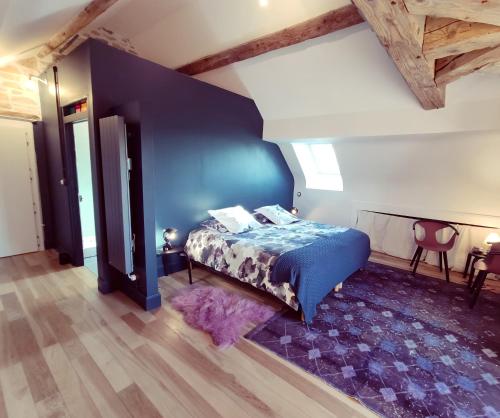 une chambre avec un lit et un mur bleu dans l'établissement Domaine de Saint Loth', à Saint-Lothain
