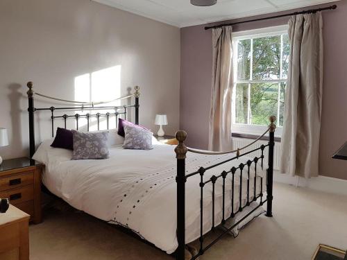 a bedroom with a large bed and a window at Hedgelea in Winkleigh