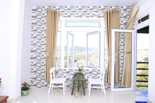 a dining room with a table and chairs and windows at Da Lat Ngoi Sao Viet in Da Lat