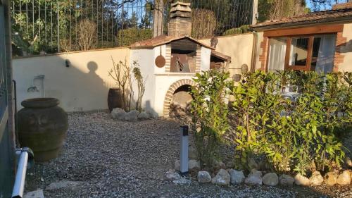 a garden with a building with a brick oven at La Limonaia Country House in Monteriggioni