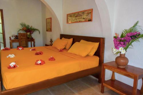 a bedroom with a bed with flowers on it at Eva Lanka Hotel - Beach & Wellness in Tangalle