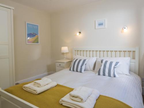 a bedroom with a white bed with towels on it at Prospects in Salcombe