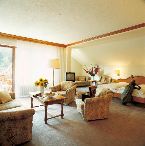 a large hotel room with a bed and a living room at Hotel garni zur Weserei in Kandern