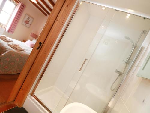 a glass shower in a bathroom with a toilet at Hawthorn Cottage in Truro