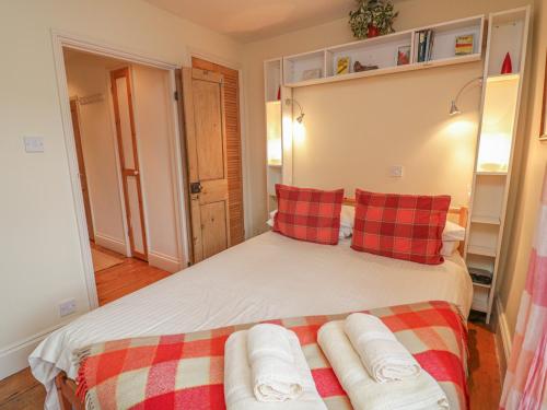 a bedroom with a bed with red and white pillows at Lee Shore in Salcombe