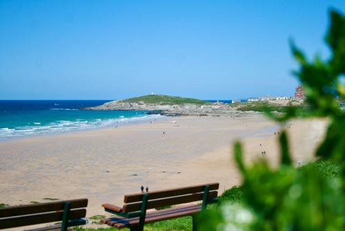 a bench on a beach with a view of the ocean at 19 Ocean Gate in Newquay