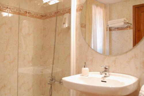 a bathroom with a sink and a shower with a mirror at Hotel Florido in Sort