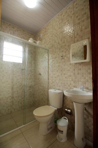 a bathroom with a toilet and a sink at Casas em Ubatuba in Ubatuba