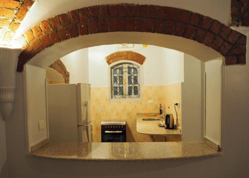 uma cozinha com um arco numa cozinha com um frigorífico em Malkata House em Luxor