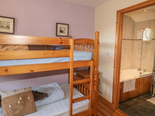 a bunk bed room with two bunk beds and a tub at Swallows Nest in Launceston