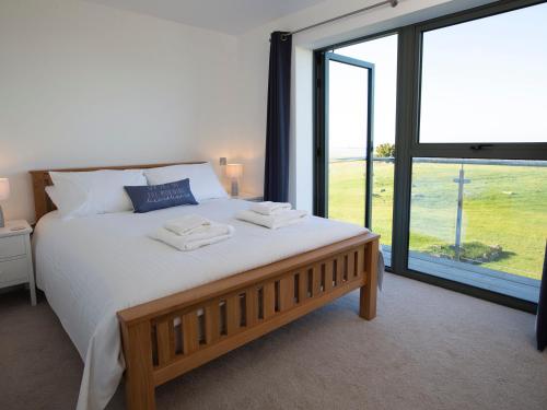 a bedroom with a large bed and a large window at 4 Ocean Reach in Malborough