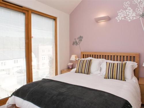 een slaapkamer met een bed en een groot raam bij Quay Lodge in Dartmouth