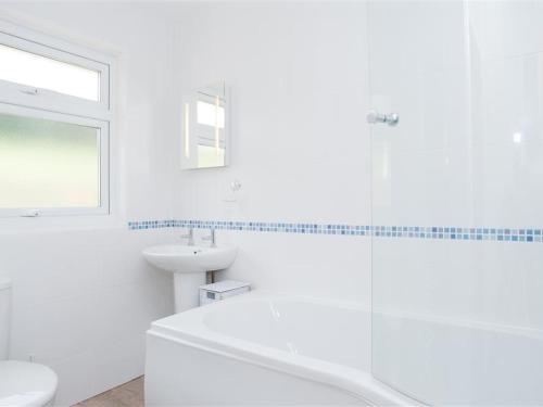 Un baño blanco con inodoro y lavabo. en Greystone, en Kingsbridge