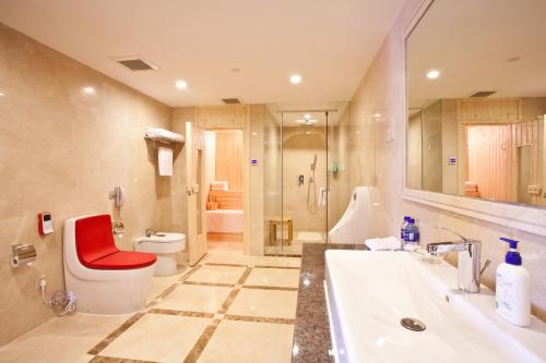 a bathroom with a sink and a toilet and a tub at Beijing Guizhou Hotel in Beijing