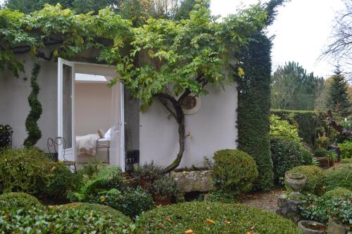 een huis met een open deur in een tuin bij La chambre blanche in Heerlen