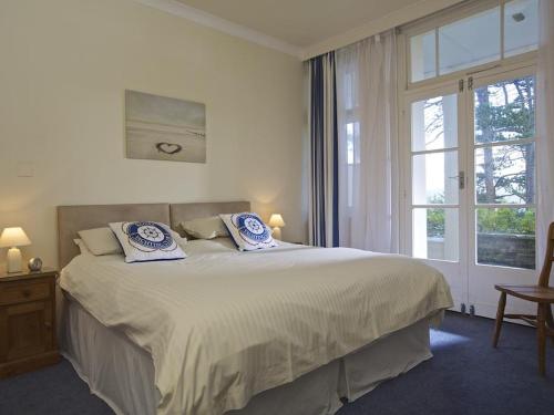 a bedroom with a large bed and a window at 4 Ringrone in Salcombe