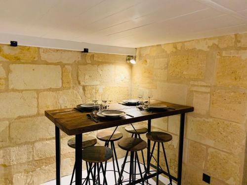 - une table dans une pièce avec des chaises et des verres à vin dans l'établissement L’Atelier d’Hugla, à Bordeaux