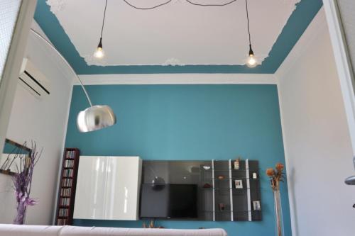 ein Wohnzimmer mit blauen Wänden und einem Sofa in der Unterkunft Funky flat in Palermo