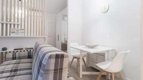 1 dormitorio blanco con 1 cama, mesa y sillas en Italianway - Fara 1, en Milán
