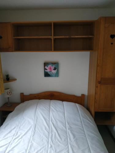 a bedroom with a white bed and wooden cabinets at Appt 10p Wifi Confort 150m activités, pistes, commerces in Superdevoluy