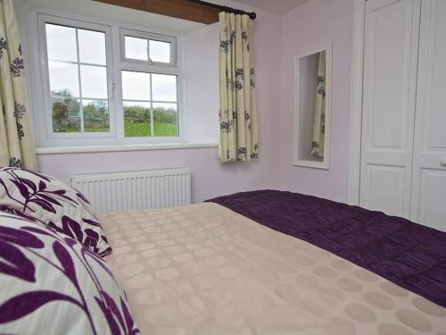 a bedroom with a bed and two windows at Cloverwell in Kingsbridge