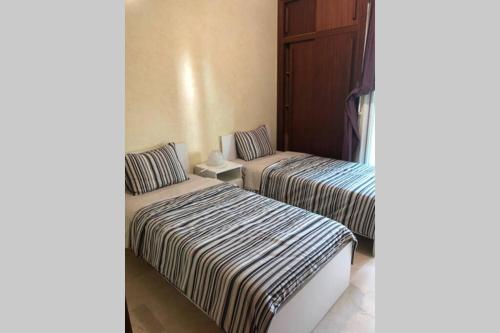 2 camas en una habitación de hotel con en La Siesta Bel appartement bord de mer avec piscine en Mohammedia