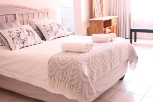 Una cama blanca con dos toallas encima. en Die Huis - Self Catering, en Bela-Bela