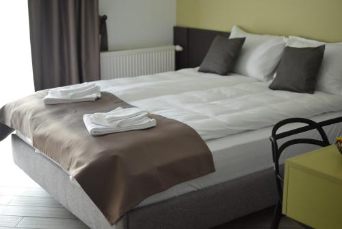 ein großes Bett mit zwei Handtüchern darüber in der Unterkunft Villa Alisia in Baile Felix