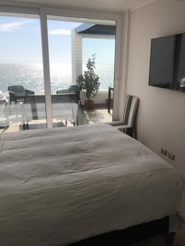 a bedroom with a large bed and a large window at Departamento Terrazas de Cochoa 2 dormitorios in Viña del Mar