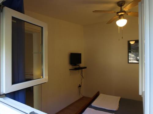 a bedroom with a ceiling fan and a window at Silba Otium in Silba