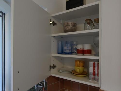a kitchen pantry with white shelves and dishes at Silba Otium in Silba