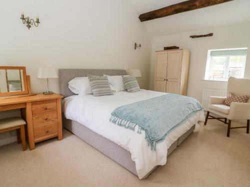 a bedroom with a bed and a desk and a chair at Croft Cottage in Skipton