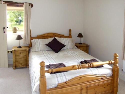 a bedroom with a wooden bed with a baseball bat on it at Honeystone in Leek