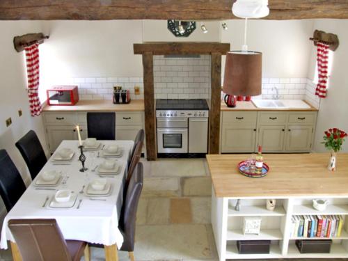 a kitchen with a white table and chairs and a table and a kitchen with at Honeystone in Leek