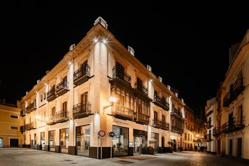 a building with lights on the side of it at night at Vincci Selección Unuk 5 GL in Seville